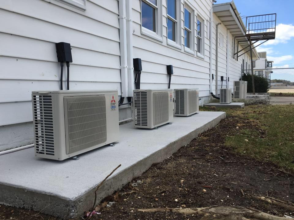 Three Air Conditioning Units Arranged Next To A House