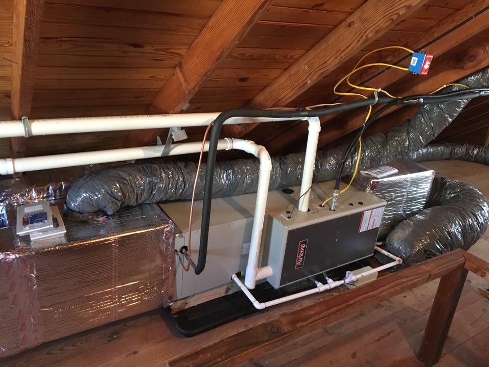 A Furnace And Air Conditioner Installed In A Spacious Attic